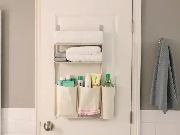 Bathroom door with an over-the-door organizer holding toiletries and towels.