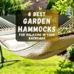 A cozy garden hammock with cushions under a tree in a sunny backyard.